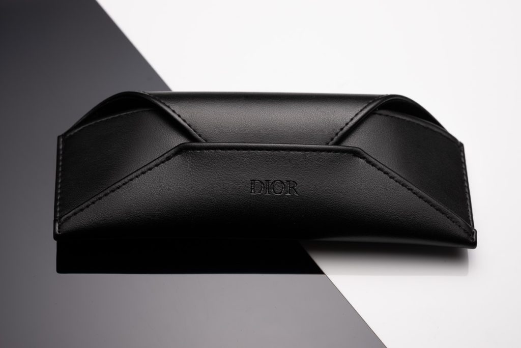Schwarzes Dior-Etui für Sonnenbrillen auf stilisiertem, kontrastreichem Untergrund – professionell fotografiert von einem Produktfotografen aus Zürich.